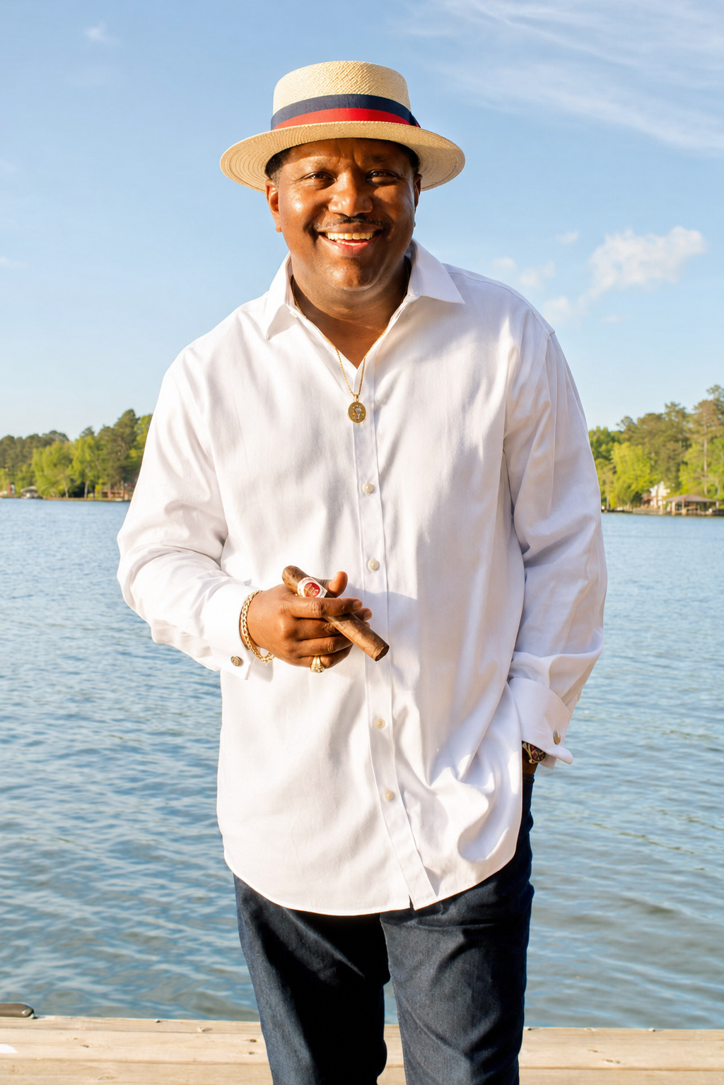 Founder of Cubano Cigars smiling by the water while holding a cigar